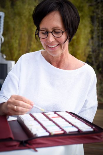 Heilpraktikerin und Homöopathin Tanja Heilingbrunner-Schorr in Wolfratshausen nimmt aus einer Globoli-Mappe ein hommöopathisches Mittel heraus